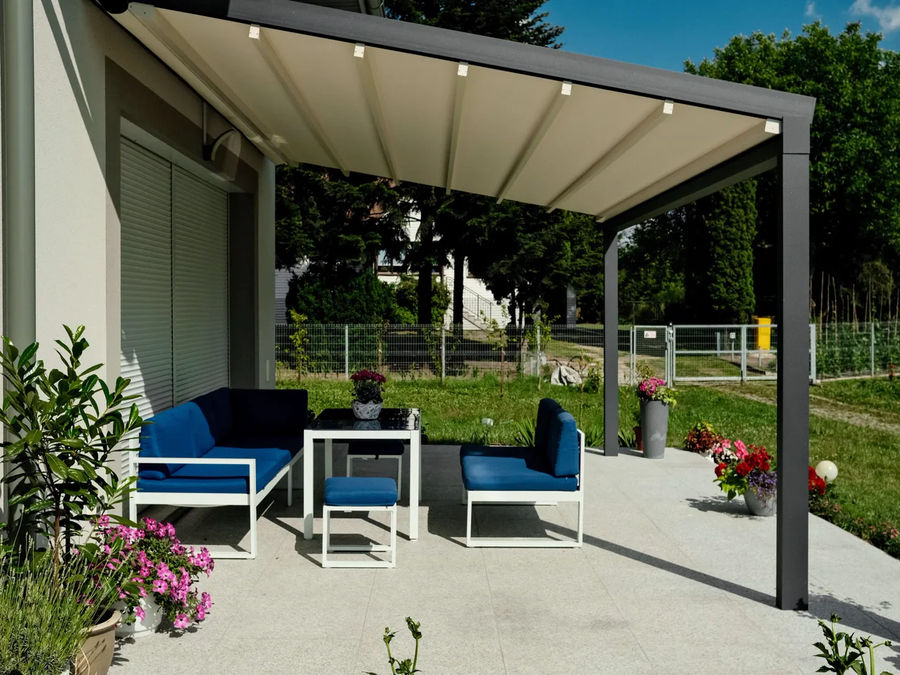 Faltpergola Portofino von Surma mit geneigtem Faltdach an klassischem Haus, RolloMax Wien