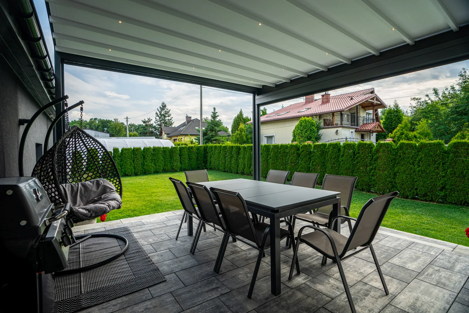 RolloMax Faltpergola Milano mit Essplatz unter dem gespannten Faltdach
