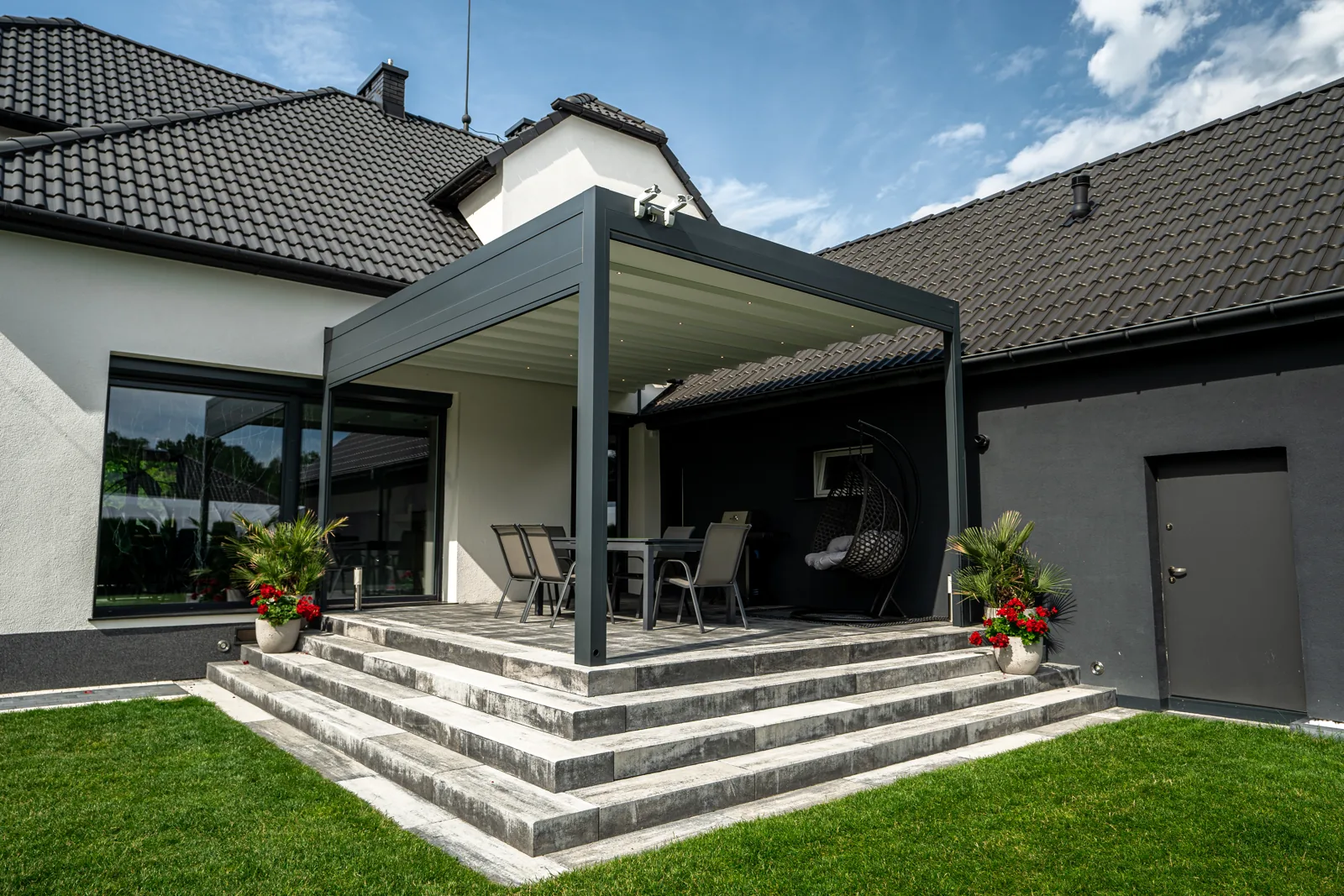 RolloMax Faltpergola Milano über einer Treppenterrasse an einem modernen Einfamilienhaus
